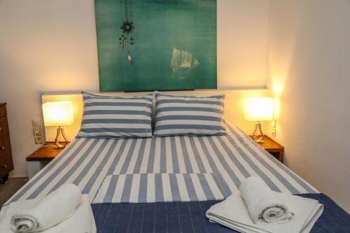 a bedroom with a bed with towels and two lamps at Golden View Villa in Skiathos Town
