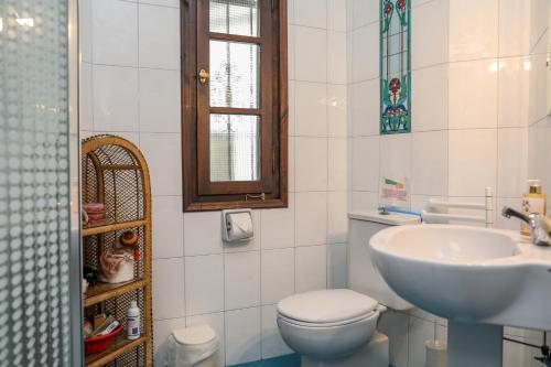 a bathroom with a white toilet and a sink at Golden View Villa in Skiathos Town