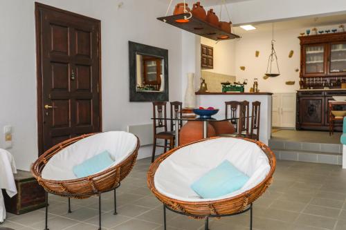 a living room with two chairs and a kitchen at Golden View Villa in Skiathos Town