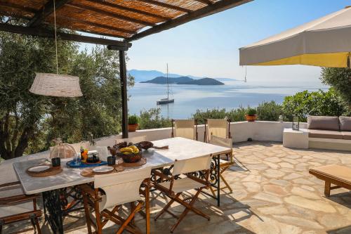 a table and chairs on a patio with a view of the ocean at Golden View Villa in Skiathos Town
