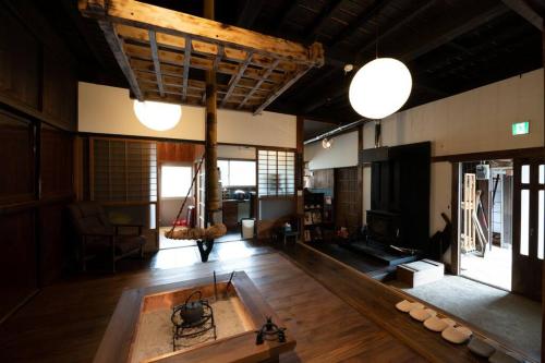 a large room with a bath tub in the middle of it at 囲炉裏つき古民家を丸ごと貸し切り「月夜見山荘」（庭にBBQグリル完成！） in Hayakawa
