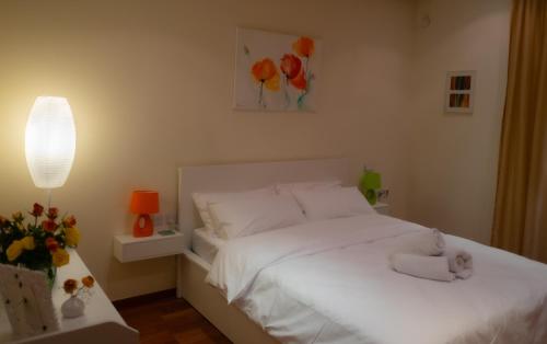 a bedroom with a white bed with a stuffed animal on it at Valletta Collection - Merchant Str Apartment with large yard in Valletta