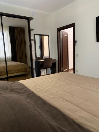 a bedroom with a bed and a desk and mirror at Петрівський in Kropyvnytskyi
