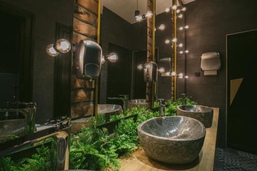 a bathroom with three sinks and a large bowl sink at Hotel Kole in Čačak