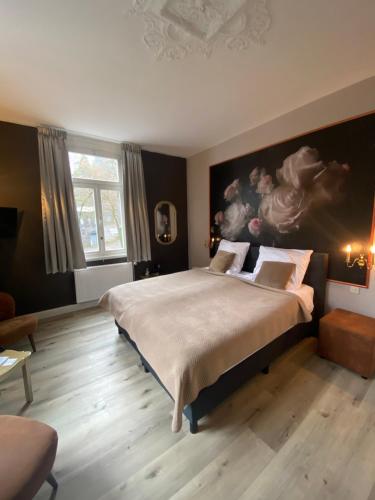 ein Schlafzimmer mit einem großen Bett und einem Gemälde an der Wand in der Unterkunft Villa Burgau B&B in Monschau
