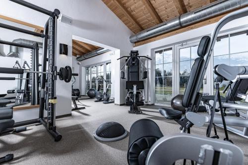 a fitness room with several treadmills and machines at Hotel Pirchnerhof in Reith im Alpbachtal