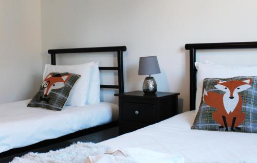 1 dormitorio con 2 camas y mesita de noche con lámpara en Abingdon - Private Flat with Garden & Parking 06 en Abingdon