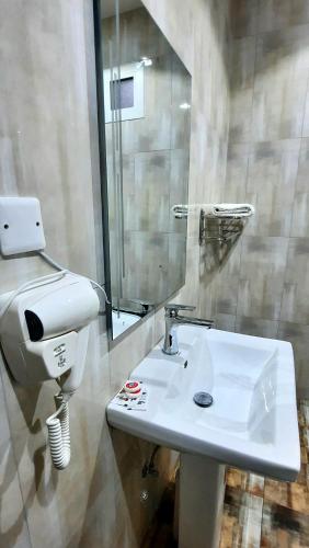 a bathroom with a sink and a toilet and a mirror at جولدن نيو جوان - Golden New Gewan - للشقق المخدومة in Abha