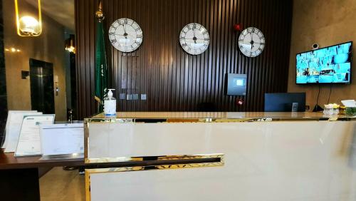 a lobby with clocks on the wall and a counter at جولدن نيو جوان - Golden New Gewan - للشقق المخدومة in Abha