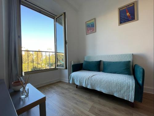 un salon avec un canapé et une grande fenêtre dans l'établissement Nice Renting - JAURES - Cosy Flat - Nice old town - Great view - AirCon, à Nice