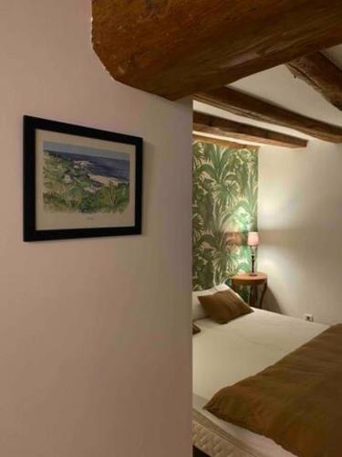 a bedroom with a bed and a picture on the wall at Le Domaine de Moroges in Moroges