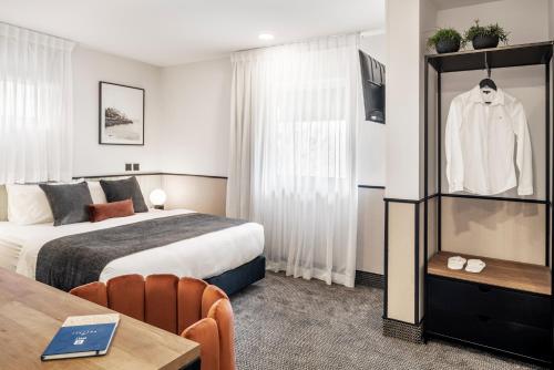 
a hotel room with a bed and a television at The New Port Hotel TLV in Tel Aviv
