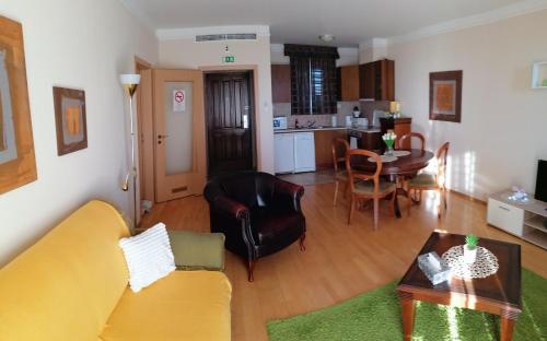 - un salon avec un canapé jaune et une table dans l'établissement Beatrix Apartments, à Bük