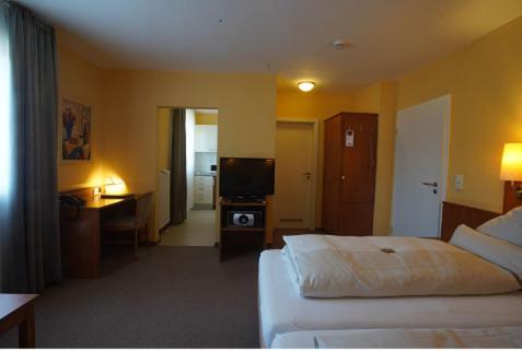 a hotel room with a bed and a television at Park Residence in Garching bei München