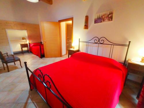 a red bed in a room with a bedroom at San Lorenzo Agriturismo in Buonconvento