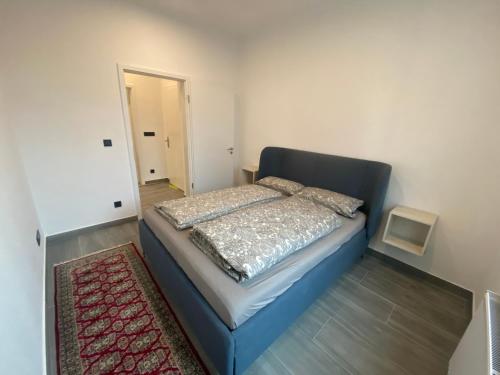 sypialnia z niebieskim łóżkiem z dywanem w obiekcie Stadtquartier Hoesch w Dortmundzie