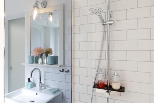 een douche in de badkamer met een wastafel en een spiegel bij Stilvolle FeWo *Rebland* Balkon-Netflix-Parking in Baden-Baden