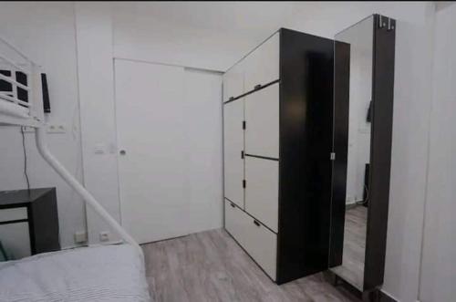 - une chambre avec un lit et une armoire noire et blanche dans l'établissement Superbe appartement cosy, à Saint-Ouen