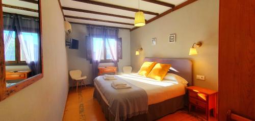 a small bedroom with a bed with yellow pillows at Hotel Judería Valle del Jerte in Cabezuela del Valle