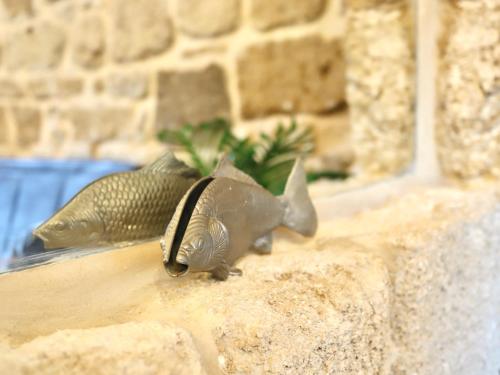 twoizards are standing on a stone wall at Stylish apartment with private parking by the marina in ‘Akko