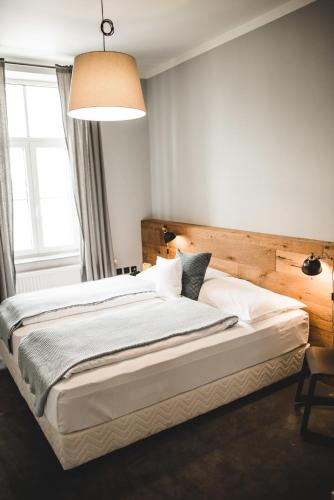 a bedroom with a large bed with a wooden headboard at Hotel city.city in Ostrava