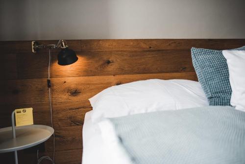 a bedroom with a bed with a wooden headboard and a lamp at Hotel city.city in Ostrava