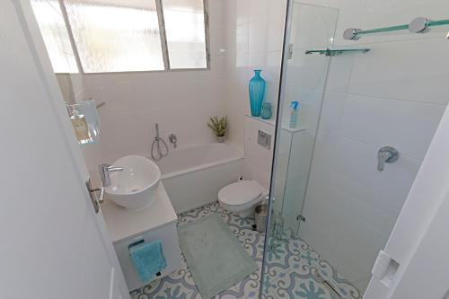 a bathroom with a shower and a sink and a toilet at Ocean-Song in Strand