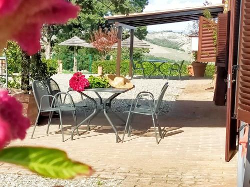 a table with chairs and flowers on a patio at San Lorenzo Agriturismo in Buonconvento