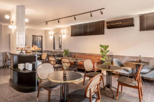 a restaurant with tables and chairs and a bar at The New Port Hotel TLV in Tel Aviv