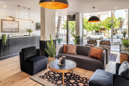 
a living room filled with furniture and a large window at The New Port Hotel TLV in Tel Aviv
