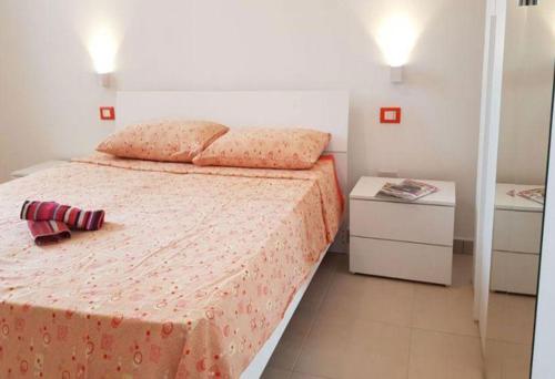 een slaapkamer met een bed met een rode deken en 2 tafels bij Trilo Torre dell Orso 5 posti Pt33 in Torre dell'Orso