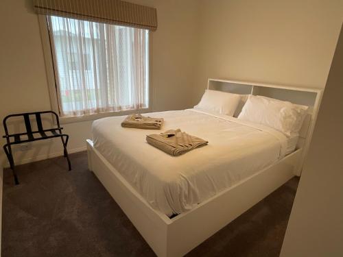 ein Schlafzimmer mit einem Bett, auf dem zwei Handtücher liegen in der Unterkunft Coghill House in Yarrawonga