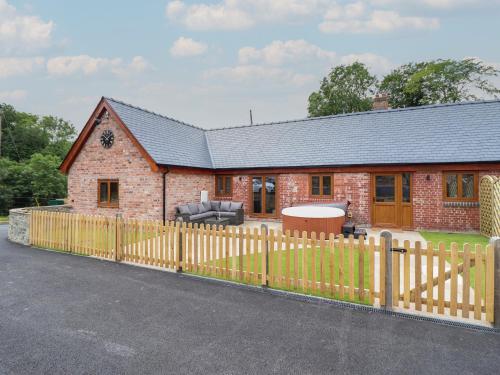 a brick house with a wooden fence in front of it at The Clockhouse in Llandyssil