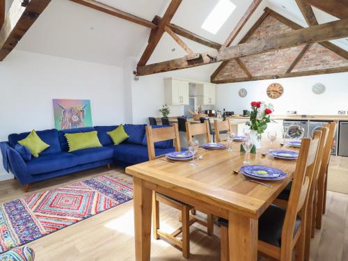 a living room with a wooden table and a blue couch at The Clockhouse in Llandyssil