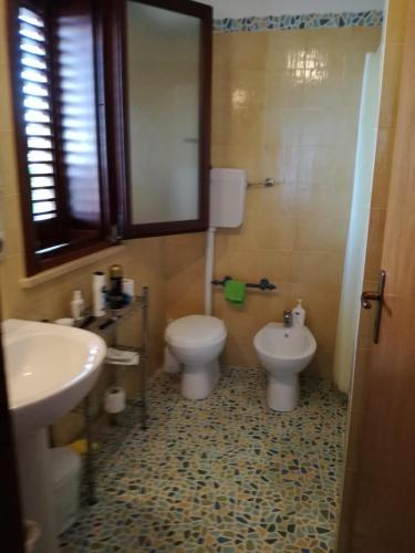 a bathroom with two toilets and a sink at Casetta Rosina in Scopello