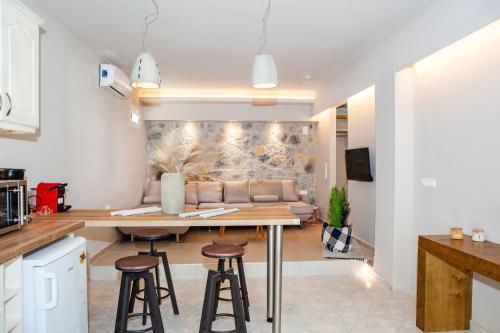 a kitchen and living room with a table and stools at Spyridoula Resort in Corfu in Gouvia