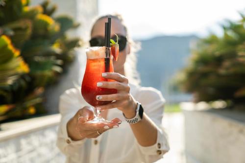 a man holding a drink in a martini glass at InterContinental Fujairah Resort by IHG in Al Aqah