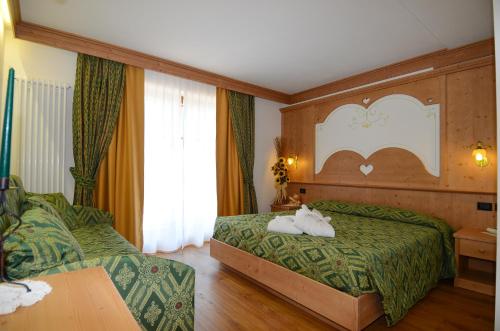 a hotel room with two beds and a table at Hotel Stella Alpina in Moena