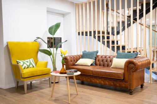 a living room with a brown couch and a yellow chair at Beecaramulo-Apiturismo in Caramulo