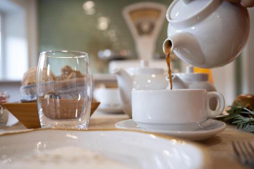 a teapot pouring tea into a cup on a table at Beecaramulo-Apiturismo in Caramulo