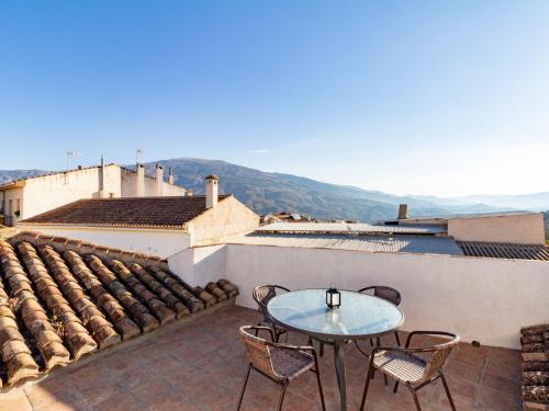 a patio with a table and chairs on a roof at Casa dos tinajas in Pinos del Valle