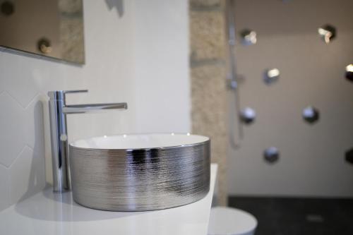 a bathroom with a silver sink and a shower at Beecaramulo-Apiturismo in Caramulo