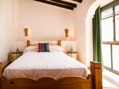 a bedroom with a bed with a large window at Casa dos tinajas in Pinos del Valle