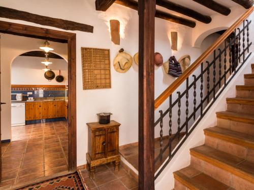 a kitchen with a stairway leading up to a kitchen with pots and pans at Casa dos tinajas in Pinos del Valle