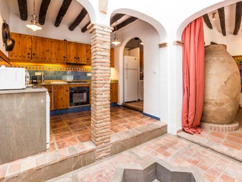 a kitchen with a stone pillar in the middle at Casa dos tinajas in Pinos del Valle