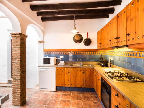 a kitchen with wooden cabinets and a counter top at Casa dos tinajas in Pinos del Valle