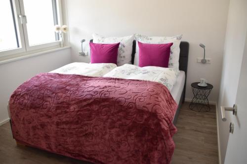 een slaapkamer met een groot bed met roze lakens en kussens bij Apartment Sabrina in Kitzbühel