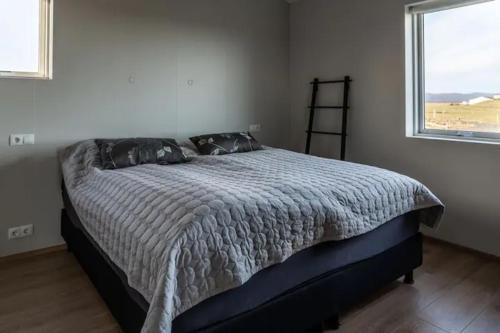 a bedroom with a bed in a room with a window at Beautiful house in the nature of West Iceland in Borgarnes