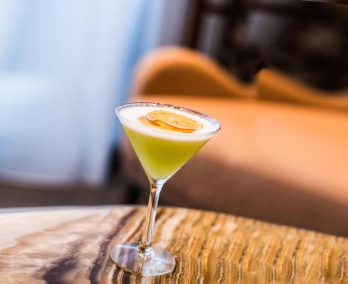 a drink in a martini glass sitting on a table at InterContinental Fujairah Resort by IHG in Al Aqah