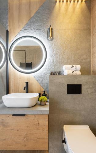 a bathroom with a white sink and a mirror at Wrota Chałubińskiego in Zakopane